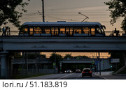 Трамвай на мосту рядом с курьером на велосипеде. Редакционное фото, фотограф Владимир Белоусов / Фотобанк Лори