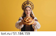 Hyper-real medium portrait of the same woman in kokoshnik presenting the karavai toward camera at chest height. Стоковое AI-видео, аниматор Виктория Кольцова / Фотобанк Лори