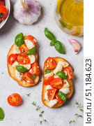 Bruschetta caprese with cherry tomatoes and mozzarella garnished with basil. Стоковое фото, фотограф Светлана Денисова / Фотобанк Лори