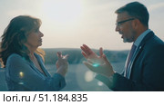 Two professionals enjoy an animated discussion outdoors, illuminated by warm afternoon sunlight, surrounded by nature's beauty. Стоковое AI-видео, аниматор Данила Большаков / Фотобанк Лори