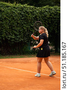 Teenage Girl Practicing Her Serves on a Sunny Tennis Court Surrounded by Lush Greenery. Стоковое фото, фотограф Aleksandr Golubev / Фотобанк Лори