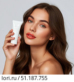 A beautiful girl is holding a tube of cosmetic cream. Стоковое AI-изображение, AI-художник Ирина Гильмуллина / Фотобанк Лори