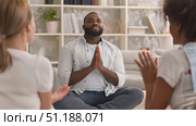 A group sits in a well-lit living room, with one leader guiding a meditation session focused on relaxation and mindfulness. Стоковое AI-видео, аниматор Данила Большаков / Фотобанк Лори