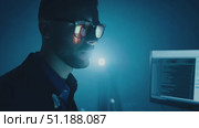 A programmer focuses intently on coding late at night in a dark room illuminated by computer screens, highlighting a dedicated workflow. Стоковое AI-видео, аниматор Данила Большаков / Фотобанк Лори