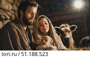 A serene depiction of the Nativity scene, featuring a bearded man and a woman gently holding a newborn child wrapped in cloth. They are dressed in traditional robes, with warm lighting casting a divine glow over the tender moment. In the background, a cow watches quietly, while a radiant star shines above, evoking themes of spirituality, Christmas traditions, and the birth of Christ. The setting symbolizes purity, peace, and the sacred celebration of Christmas in Christian culture. Стоковое AI-видео, аниматор Ксения Чунаева / Фотобанк Лори