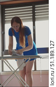 Housewife inspecting and ironing a white t shirt on an ironing board. Стоковое видео, видеограф Константин Шишкин / Фотобанк Лори