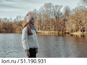 Teenage Girl Enjoys a Tranquil Autumn Afternoon by the Lakeside in a Peaceful Park Setting. Стоковое фото, фотограф Aleksandr Golubev / Фотобанк Лори