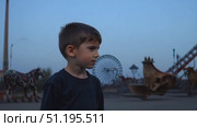 A curious boy wanders through an abandoned amusement park as dusk settles, showcasing the haunting beauty of forgotten rides and attractions. Стоковое AI-видео, аниматор Данила Большаков / Фотобанк Лори