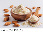 Almond flour. Almond nuts and almond flour in a wooden bowl and spoon. White table background. Grated almonds pile. Gluten-free produce for health. Low Carb Keto, celiac, paleo, and wheat-free diets. Стоковое AI-изображение, AI-художник Марина Демидюк / Фотобанк Лори