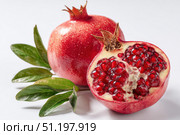 Pomegranates. Pomegranate isolated on a white transparent background. Juicy garnet fruit whole and its half with leaves and details. Piece of pomegranate with seeds. Side view. Freshness and abundance. Стоковое AI-изображение, AI-художник Марина Демидюк / Фотобанк Лори