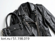 Black leather jacket with zippers and pockets and black leather stylish bag. Modern outerwear. Close-up. Fashion background. Autumn urban street clothes. Fashionable concept. Women's casual day outfit. Стоковое AI-изображение, AI-художник Марина Демидюк / Фотобанк Лори