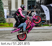 Девушка (Stunt Champ Дарья Харченко) и мужчина на спортивном розовом мотоцикле, акробатические трюки. Редакционное фото, фотограф Илья Лернер / Фотобанк Лори