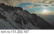 Rocky snow mountains and sunset sun. Стоковое видео, видеограф Михаил Коханчиков / Фотобанк Лори