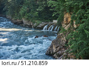 A waterfall of three streams flows into a mountain river. Beautiful natural landscape. Стоковое фото, фотограф Наталия Кирсанова / Фотобанк Лори