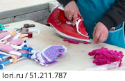 a seamstress scribbles clothes for dolls on a typewriter and smoothes it with an iron. Стоковое видео, видеограф Алексей Сергеев / Фотобанк Лори