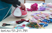 a seamstress scribbles clothes for dolls on a typewriter and smoothes it with an iron. Стоковое видео, видеограф Алексей Сергеев / Фотобанк Лори