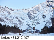 Cei, Russia. - January 06, 2024: A ski lift is visible against the background of a snow-covered mountain. The ski lift is surrounded by trees and snow. Редакционное фото, фотограф Наталия Кирсанова / Фотобанк Лори