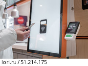 January 3, 2025 Krasnoyarsk Russia. Payment by Tinkoff T-bank credit card via Sberbank's payment terminal. Online restaurant order. The inscription in Russian on the terminal means Pay as you wish. The contactless payment option at a kiosk improves customer convenience and efficiency. Редакционное фото, фотограф Владимир Разгуляев / Фотобанк Лори