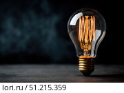 Glowing Yellow Light Bulb. Illuminated Light bulb on dark black background banner. Creative Technology. Vintage Edison Bulbs. Warm Illumination in a night space. New idea, brainstorming concept. Стоковое AI-изображение, AI-художник Марина Демидюк / Фотобанк Лори