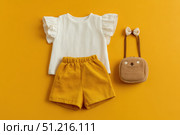 Fashion look of baby girl clothes and accessories. Set of muslin blouse, shorts, hairband and bag. Trendy cute tuff background for newborn. Toddler apparel. Female kid outfit. Pastel child wear set. Стоковое AI-изображение, AI-художник Марина Демидюк / Фотобанк Лори