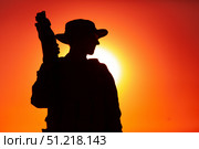 Silhouette of a soldier standing with bullpup submachine gun against a sunset sky. Oleg Zabielin / Stocktrek Images/TASS. Стоковое фото, агентство ТАСС / Фотобанк Лори