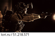 Modern soldier in combat uniform, helmet and radio headset, shooting handgun in the darkness. Oleg Zabielin / Stocktrek Images/TASS. Стоковое фото, агентство ТАСС / Фотобанк Лори