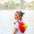 Hanoi, Vietnam - 29.04.2025: Side view portrait of cute little girl in white dress and red Non la - traditional Vietnamese straw hat standing near lake in Hanoi on sunny day. Редакционное фото, фотограф Ирина Михайличенко / Фотобанк Лори