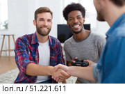 Male friends bonding while gaming, sharing handshakes and genuine laughter during multiplayer session, enjoying camaraderie in comfortable home environment. Стоковое AI-изображение, AI-художник Юрий Поздников / Фотобанк Лори