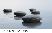 Smooth, dark stepping stones emerge from a serene body of water, forming a tranquil path across the surface, inviting contemplation and a sense of peace. Стоковое AI-видео, аниматор Юрий Поздников / Фотобанк Лори