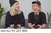 Young women in casual attire relaxing on sofa, gaming together with joyful laughter and playful interaction. Стоковое AI-видео, аниматор Юрий Поздников / Фотобанк Лори