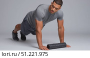 Muscular sportsman doing push ups on foam roller, highlighting core strength, stability, and fitness commitment during challenging gym training session. Стоковое AI-видео, аниматор Юрий Поздников / Фотобанк Лори
