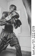 Professional boxer intensely training with punching bag, demonstrating raw power and refined technique through gritty monochrome athletic performance. Стоковое AI-видео, аниматор Юрий Поздников / Фотобанк Лори