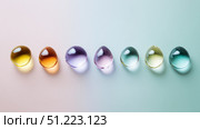 Minimalist design with clear candy drops aligned on pastel background. Стоковое AI-изображение, AI-художник ALLA YURTAYEVA / Фотобанк Лори