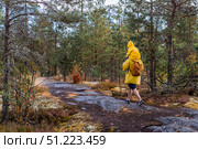 Tourism. Hiking. Ladoga skerries. Father and son tourists in yellow raincoats on stone islands in the forest. Republic of Karelia, Russia. Стоковое фото, фотограф Photojuli / Фотобанк Лори