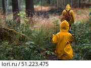 Tourism. Hiking. Ladoga skerries. Father and son tourists in yellow raincoats on stone islands in the forest. Republic of Karelia, Russia. Стоковое фото, фотограф Photojuli / Фотобанк Лори