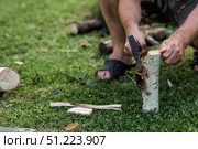 The axe is in the man's hand and is stuck in a birch log. Preparing firewood for the winter season. Logging. Timber, tools for cutting wood. Стоковое фото, фотограф Photojuli / Фотобанк Лори
