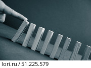 Domino has Fallen in a Row. Domino theory. Effect. Hand with Finger is Pointing and Pushing the Falling Wood Blocks. Risk Management, Revolution Concept. Affect Business. Closeup. Manifestation. Red. Стоковое фото, фотограф Марина Демидюк / Фотобанк Лори