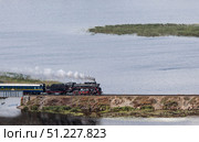 An old Soviet L-series steam locomotive. The Ruskeala Express retro train is driving along the lake. Side view from above. Russia, Republic of Karelia, Sortavala, August 11, 2025. Редакционное фото, фотограф Photojuli / Фотобанк Лори