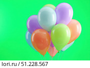 Colorful Balloons flying on green screen. Multi-colored balls move across a green background. Chroma key. Festive decoration. Valentine's Day, Birthday. Party shiny balloons bunch swaying on chromakey. Стоковое AI-изображение, AI-художник Марина Демидюк / Фотобанк Лори
