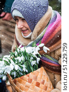 New Year's card 2026. Russian fairy tale for 12 months. A girl in a fur coat with a bouquet of snowdrops in a basket. It's snowing. New Year's card 2026. Moscow, December 26, 2024. Редакционное фото, фотограф Photojuli / Фотобанк Лори