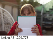Девочка закрыла лицо книгой. Стоковое фото, фотограф Светлана Зотова / Фотобанк Лори