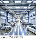 A Spacious Car Service Center With Rows of Vehicles Awaiting Repair. Generative AI. Стоковое AI-изображение, AI-художник Roman Zavorotny / Фотобанк Лори