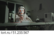Person in hoodie and glowing mask sitting at desk in dark room, concept of hidden identity and digital privacy in online space. Perfect for cybersecurity, anonymity and internet themes. Стоковое видео, видеограф Енваев Андрей / Фотобанк Лори