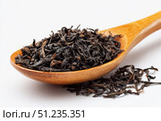 Dry black tea leaves in a wooden spoon isolated on white background. Pile of Dried fermented tea. Black Tea Leaves Heap. Close Up, Macro. Texture. Copy Space. Dried Tea. Abstract Food Drink Backdrop. Стоковое AI-изображение, AI-художник Марина Демидюк / Фотобанк Лори