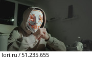 Masked figure in hoodie representing hacker culture and cyber threats. Concept of data theft, cyber crime and security breach in digital world. Стоковое видео, видеограф Енваев Андрей / Фотобанк Лори