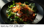 Soba noodles salad with radishes, carrots, and greens presenting culinary fusion. Стоковое фото, фотограф David Kashakhi / Фотобанк Лори