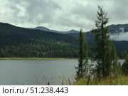 Serene Mountain Lake with Lush Greenery Under Cloudy Sky. Стоковое фото, фотограф Igor Bastrakov / Фотобанк Лори