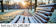 Winter morning sunlight illuminating a snow-covered park bench along a frosty path. Стоковое AI-изображение, AI-художник Ольга Невская / Фотобанк Лори
