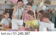 Teenage girl tries to sew surrounded by classmates, female teacher comments and help. Стоковое видео, видеограф Яков Филимонов / Фотобанк Лори