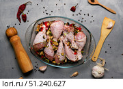 Raw chicken legs and lots of spice in a transparent dish on a grey background. Стоковое фото, фотограф Енваев Андрей / Фотобанк Лори